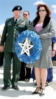 Roberta Stewart holding a wreath for her late husband: Sgt. Patrick Stewart
